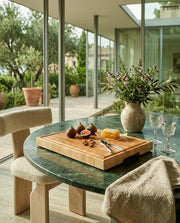 Tagliere end-grain in acero usato come vassoio da portata con fichi, mandorle e miele su tavolo in marmo verde