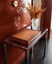 Tagliere end-grain in faggio con cornice in mogano su consolle laccata in un ingresso rosso con orchidee