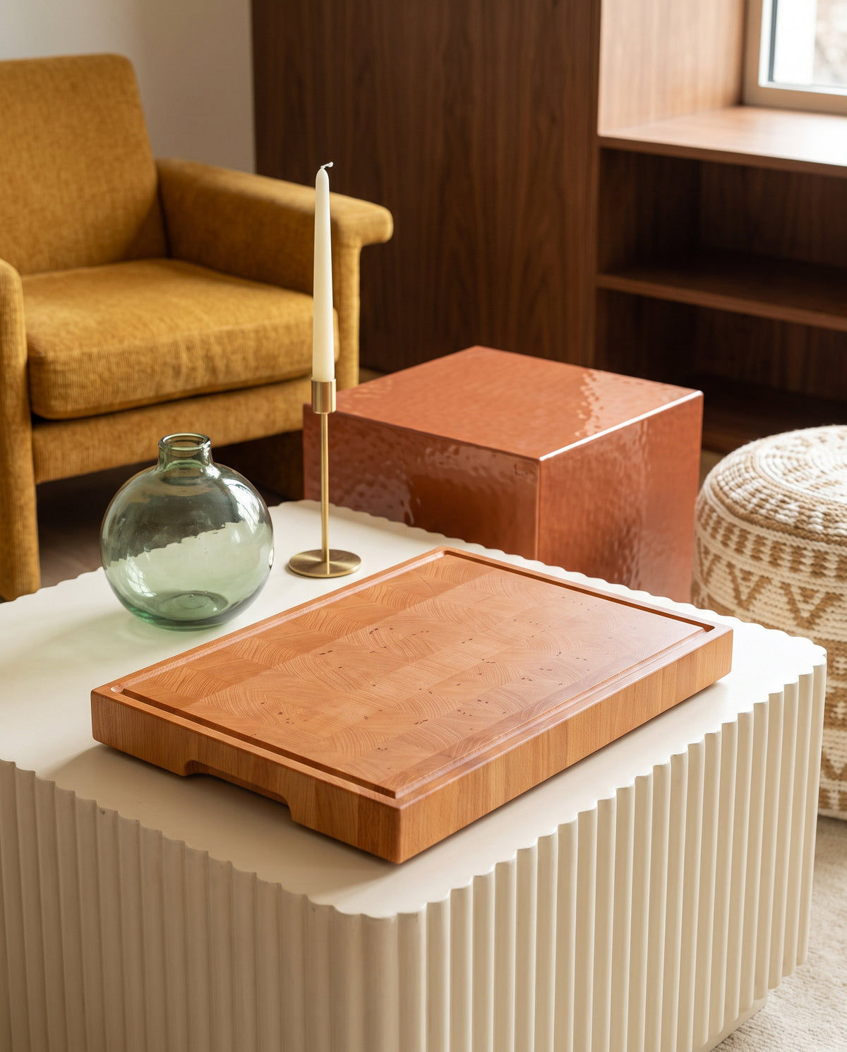 Tagliere end-grain in legno massello Bottega Ruta su tavolino bianco in un soggiorno dal design caldo