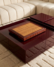 Tagliere end-grain in rovere con cornice in mogano su tavolino laccato bordeaux in un soggiorno di design