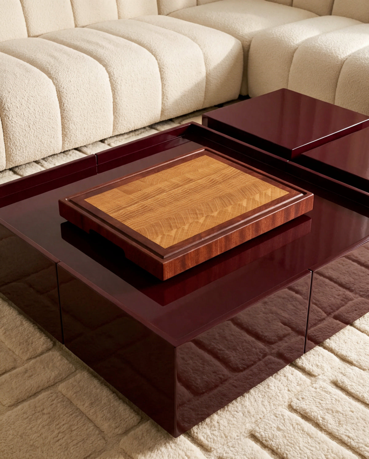 Tagliere end-grain in rovere con cornice in mogano su tavolino laccato bordeaux in un soggiorno di design