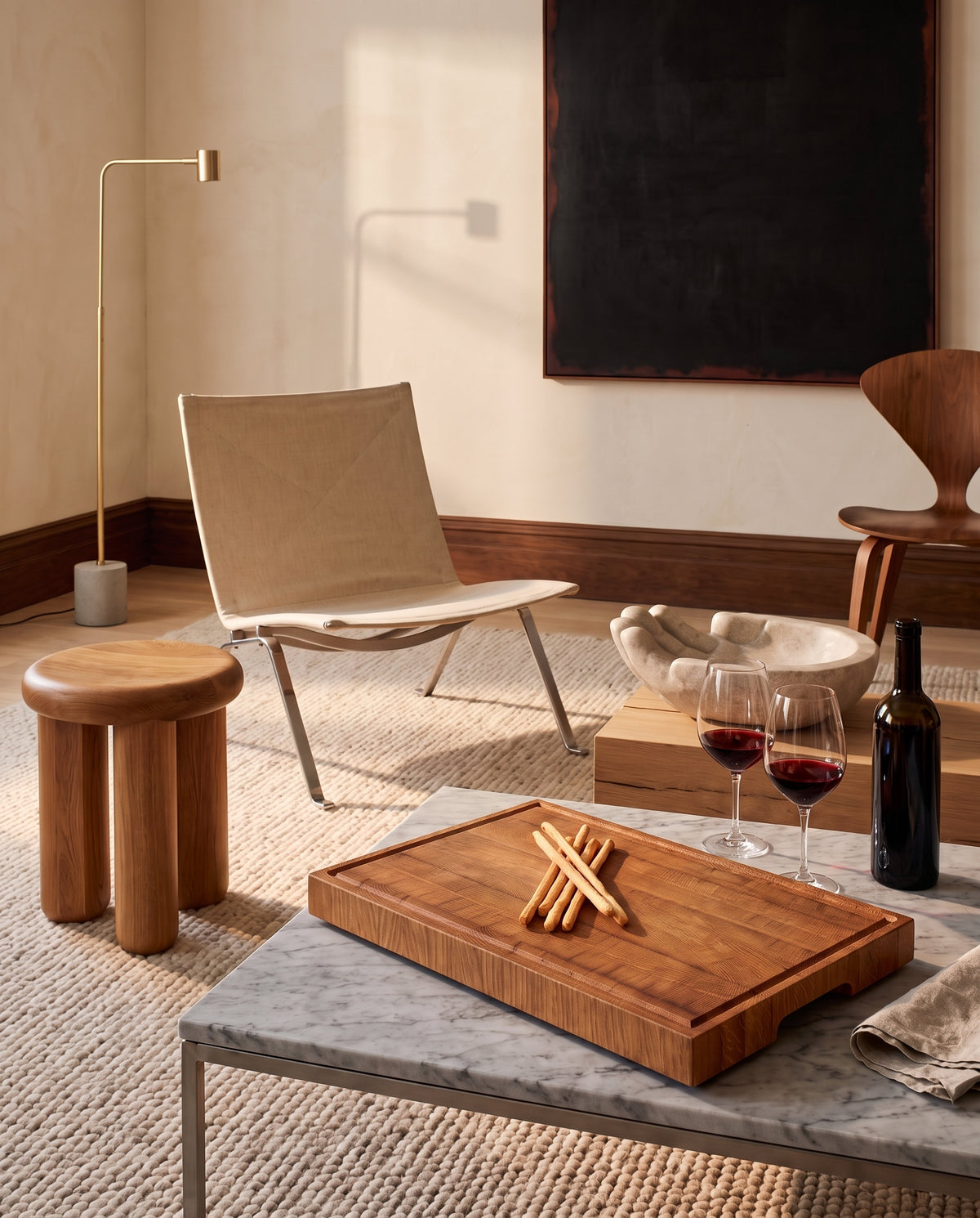 Tagliere end-grain in rovere come vassoio per l'aperitivo con grissini e vino rosso su tavolino in marmo
