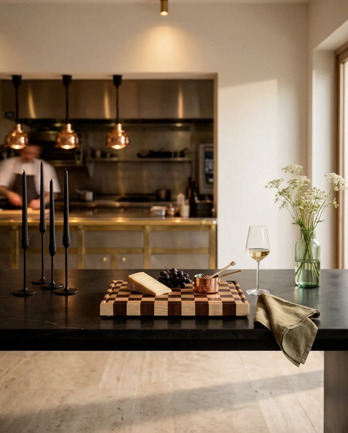 Tagliere end-grain a scacchiera in mogano e acero con formaggio, uva e miele su bancone in pietra nera